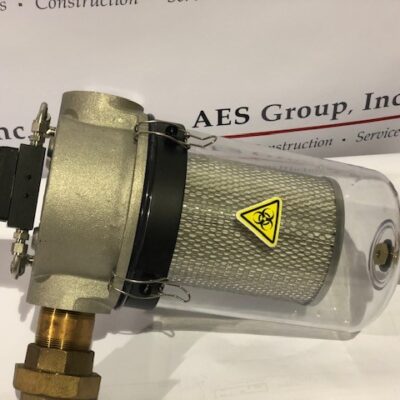 A cylindrical industrial filter with a transparent casing, metal mesh inside, a biohazard warning symbol, a pressure gauge, and brass fittings, displayed on a white surface near an AES Group, Inc. banner.