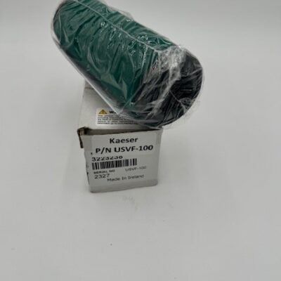 A green cylindrical Kaeser Standard 100 KVF Element (P/N USVF-100), wrapped in plastic, sits atop a white box bearing its part number and product/manufacturing details, all set against a plain white background.