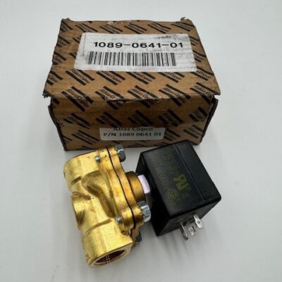 An Atlas Copco Exhaust Valve G1/2 (P/N 1089 0641 01) with a black electrical component is shown in front of a brown branded box bearing a barcode and part number, all set against a white background.