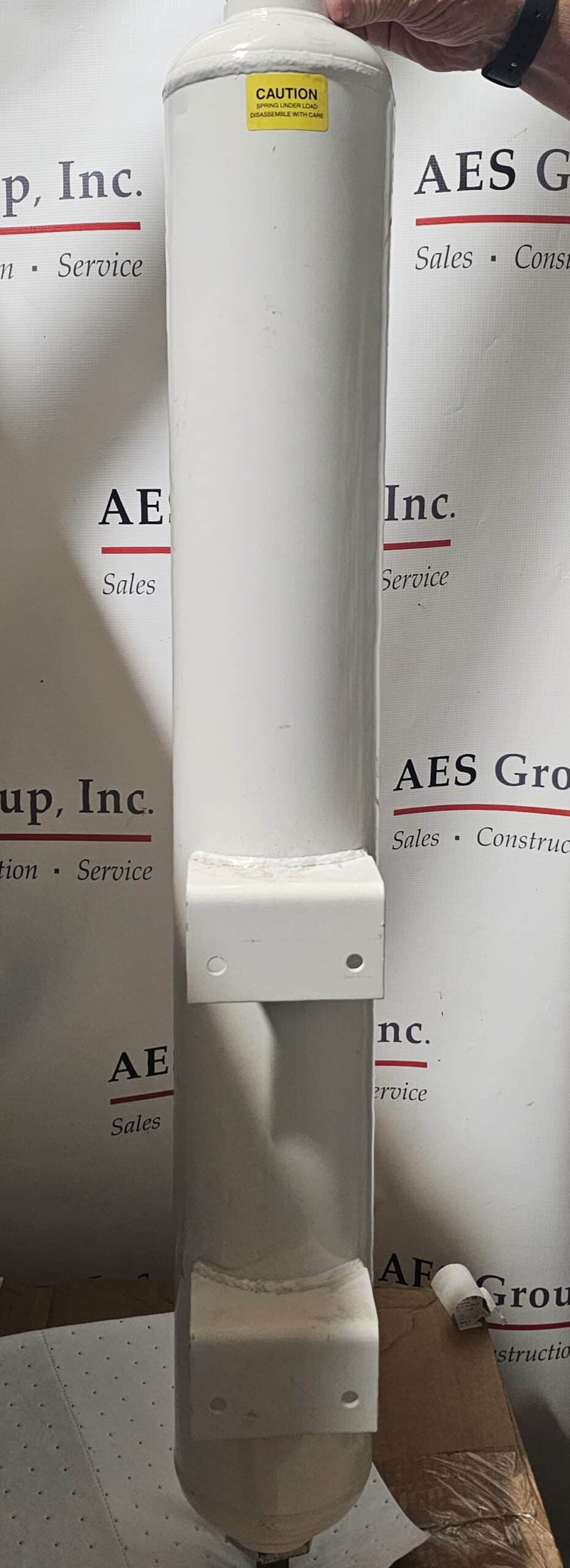 A Powerex, Inc. Desiccant Dryer Tank - Loaded (P/N SK108300AJ), a large white cylindrical unit with mounting brackets and a caution label on top, stands vertically before an AES Group, Inc. logo backdrop.